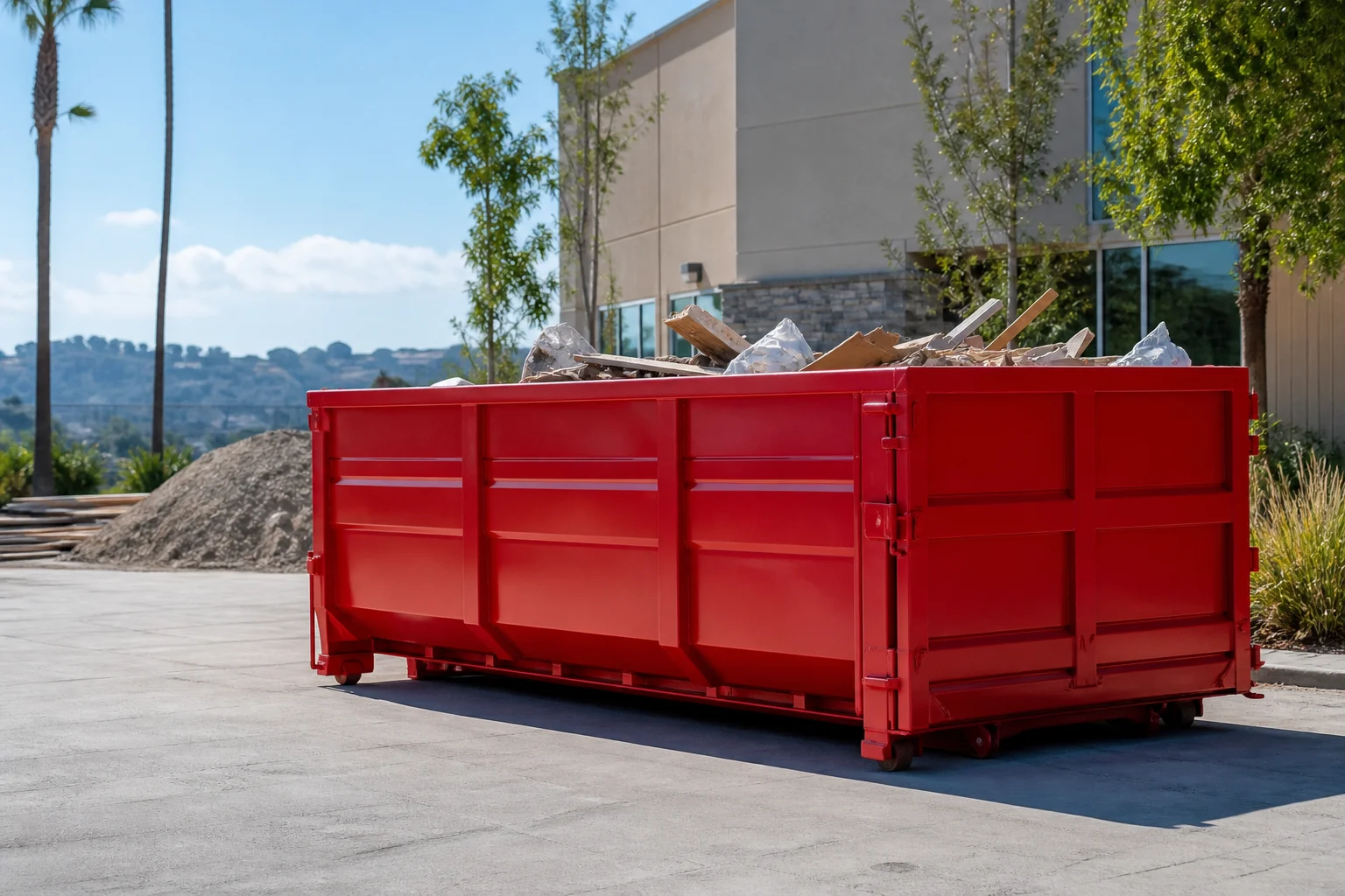 Red roll-off dumpster staged near construction material for service overview context